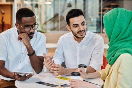 Candid image of a diverse team in a collaborative meeting. Focus on conversation and teamwork.