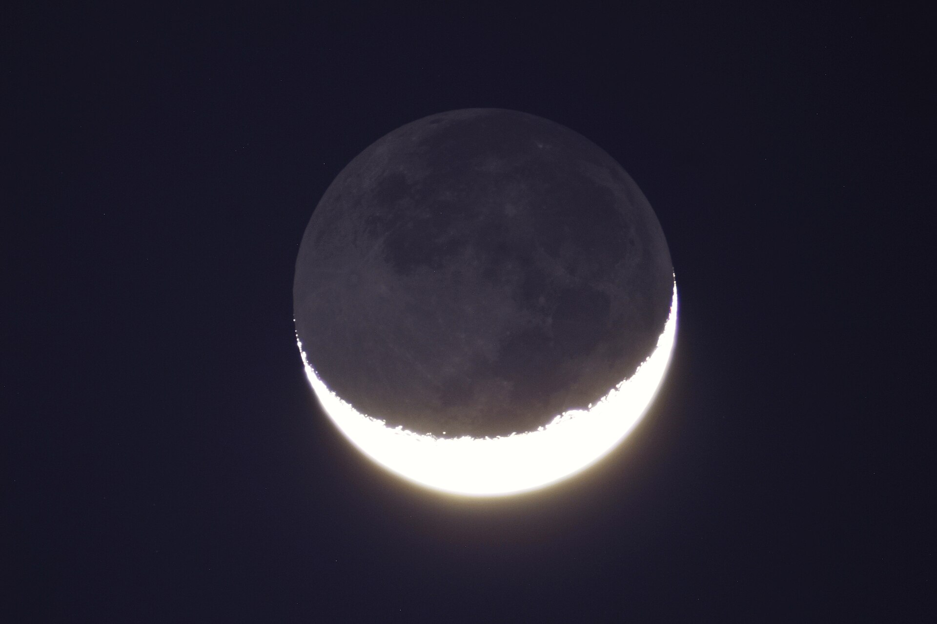 Thin crescent Moon with its dark disk faintly lit by earthshine